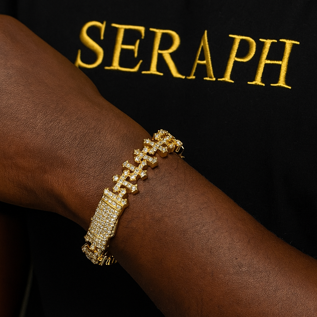 Cross shaped link bracelet with a row of gemstones and thick gold plating.