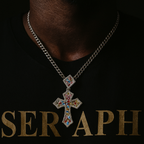 Cross pendant decorated with stones of various colours, forming a rainbow pattern.