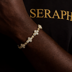 Slim chain bracelet with a small cross charm encrusted in stones.