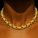 Barbed‑wire inspired chain necklace with shimmering stones and thick gold plating.